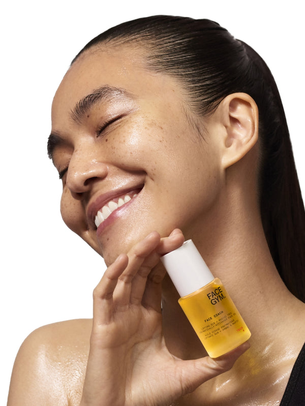 Face Coach face oil model shot holding product